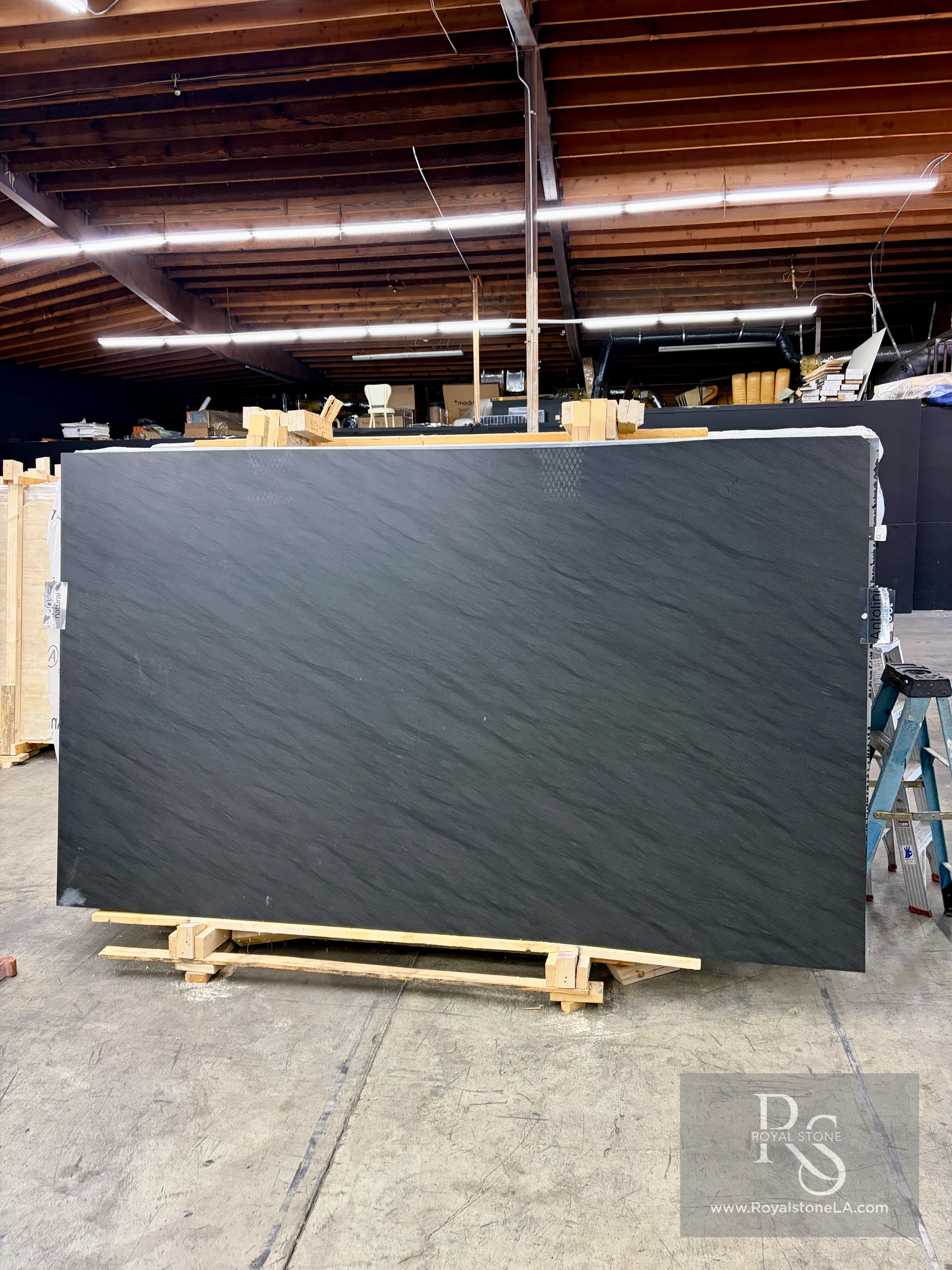 2cm Antolini Carbon Black EE939 Bohemian leathered quartzite slab, 75 by 128 inches, with a near-black charcoal field at the Royal Stone yard in Los Angeles