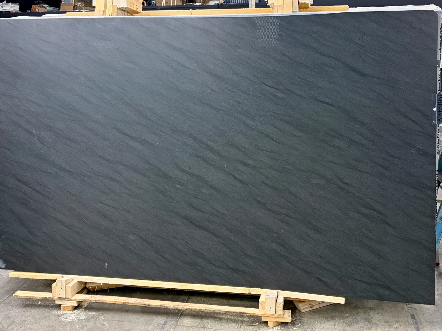 Close view of the leathered surface on Antolini Carbon Black EE939, showing a near-black charcoal field with a soft slate-like texture at Royal Stone