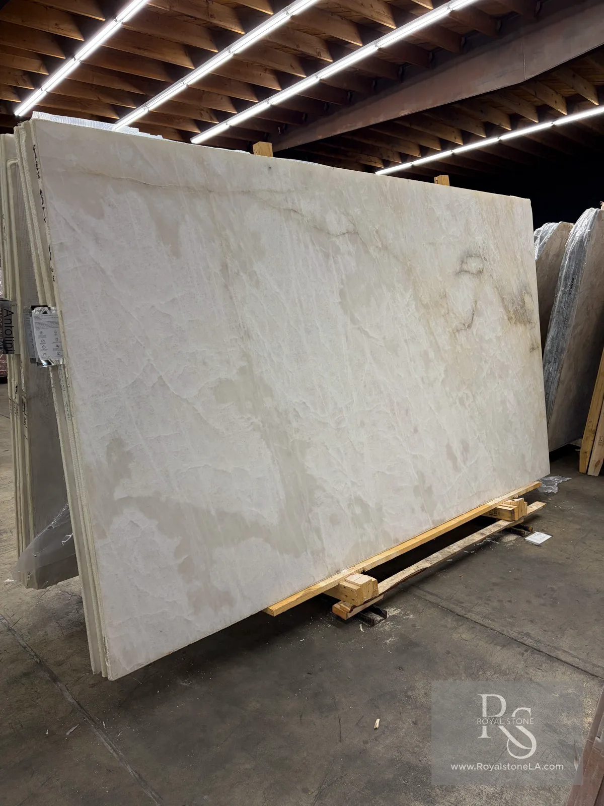 Antolini Cristallo Babyrose Top YG627 honed quartzite slab, 78 by 136 inches, with a soft blush-white field and quiet gold-grey veining at the Royal Stone Los Angeles yard