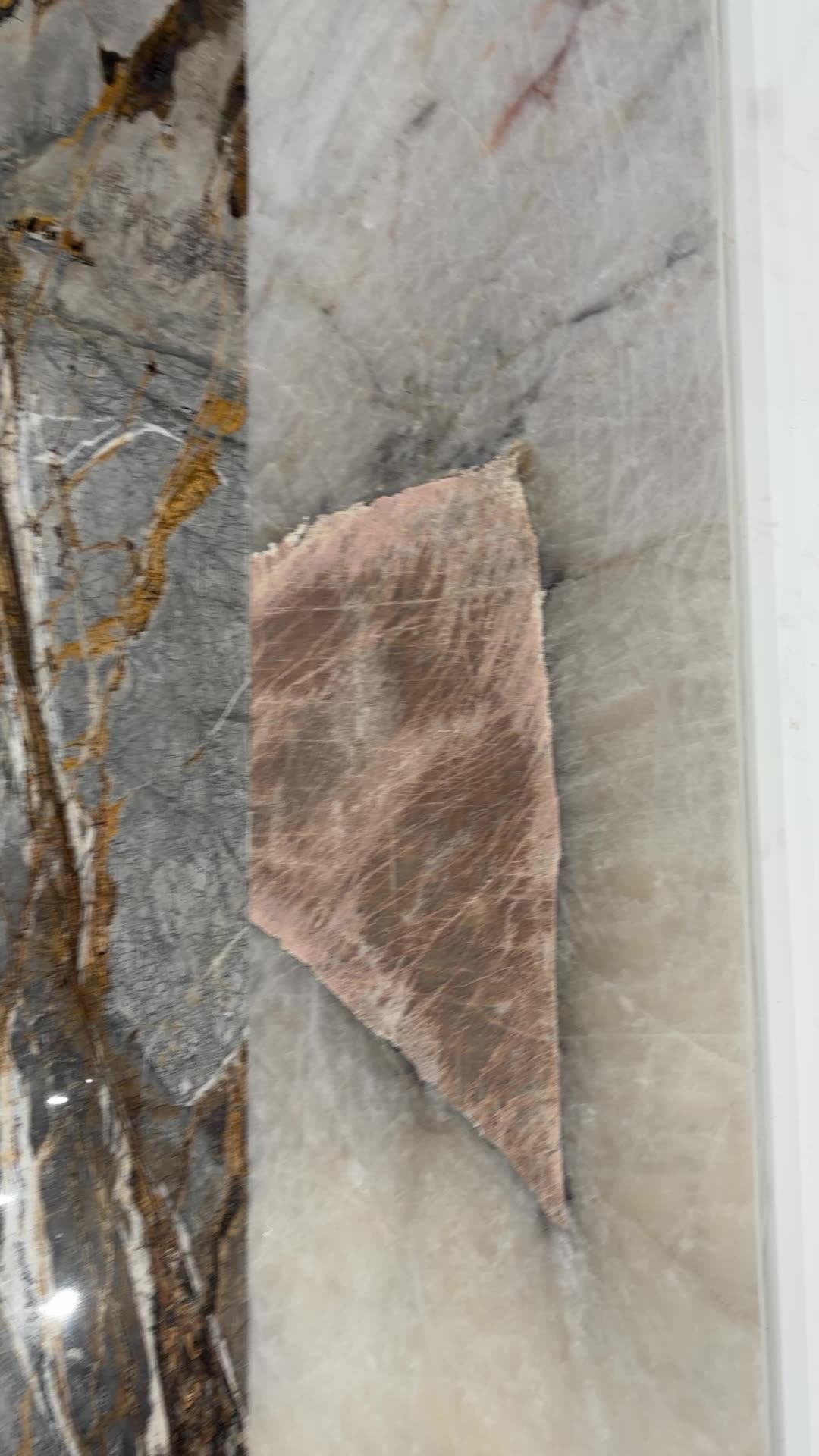 Close view of textured natural stone slabs on the Antolini display wall at Royal Stone