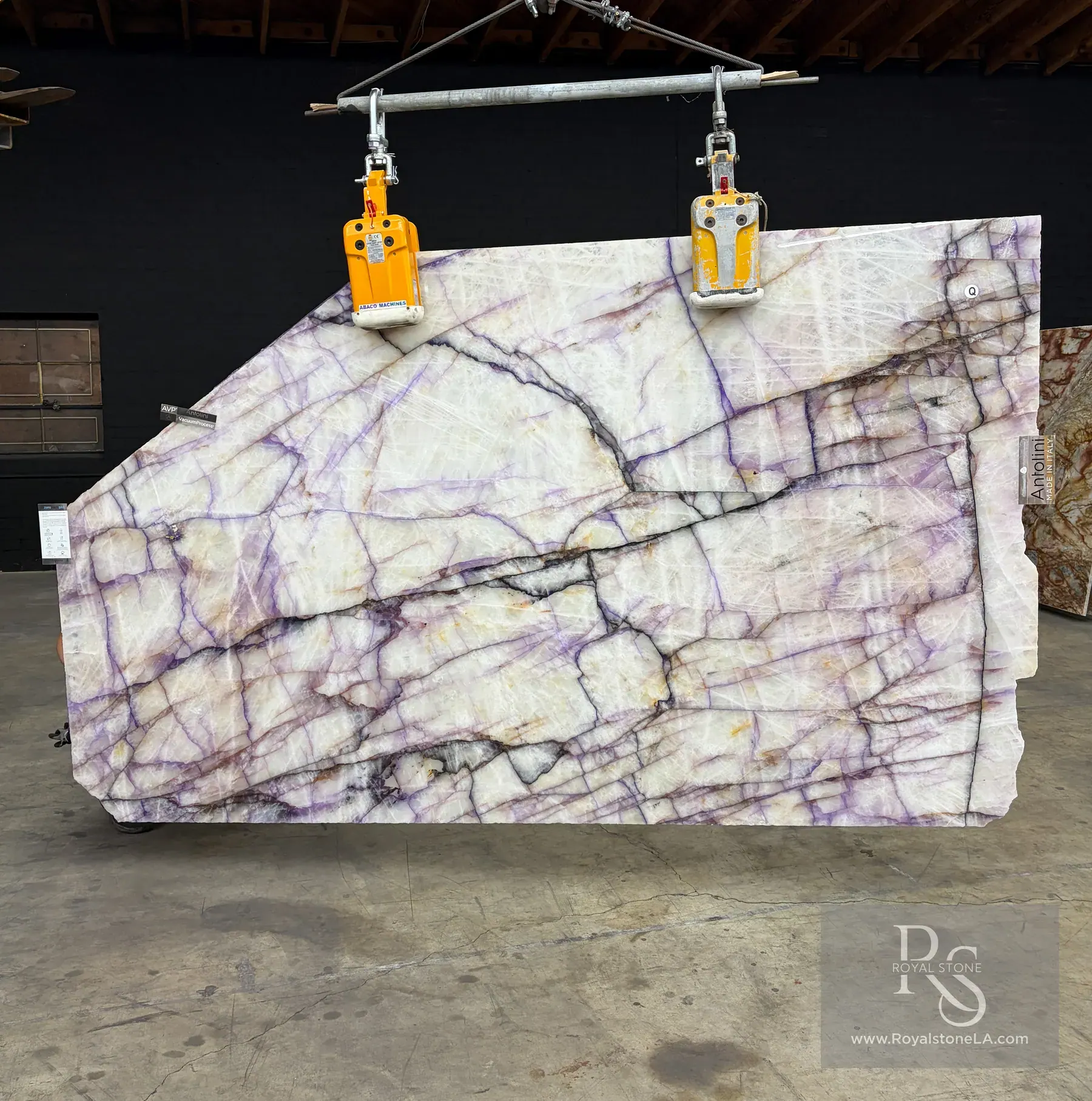 2cm Antolini Cristallo Trasviolet Treated DW654 polished quartzite slab, 70 by 102 inches — violet streaks running across a clear white crystalline field with threads of warm iron oxide, photographed front-lit at the Royal Stone yard in Los Angeles