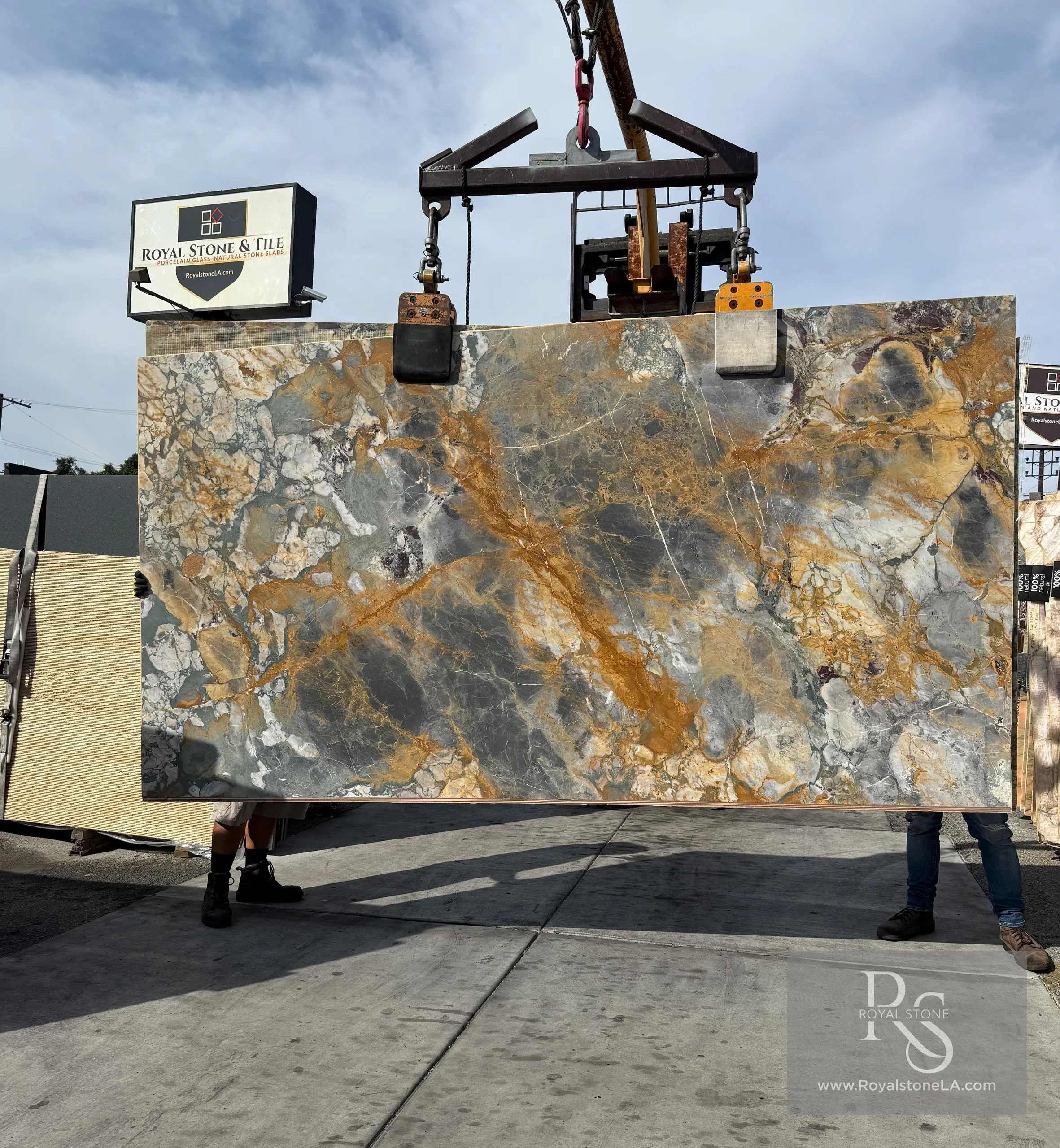 Antolini Breche De Vendome marble slab showing dark gray brecciated pattern with golden amber veins in honed finish