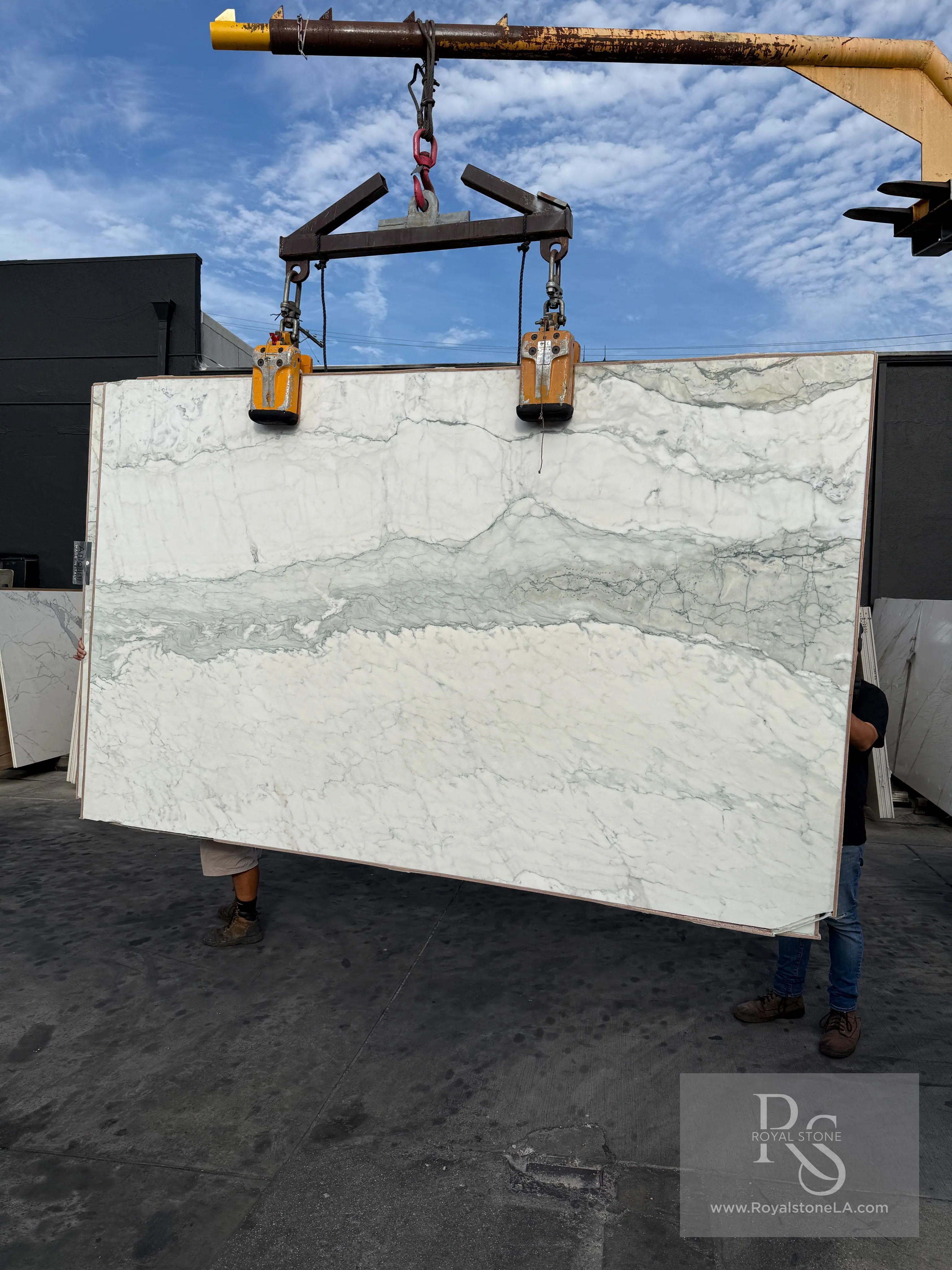 Antolini Calacatta Breccia Turquoise Light YG556 marble slab on the crane at the Royal Stone yard, white field crossed by a band of soft turquoise and green breccia