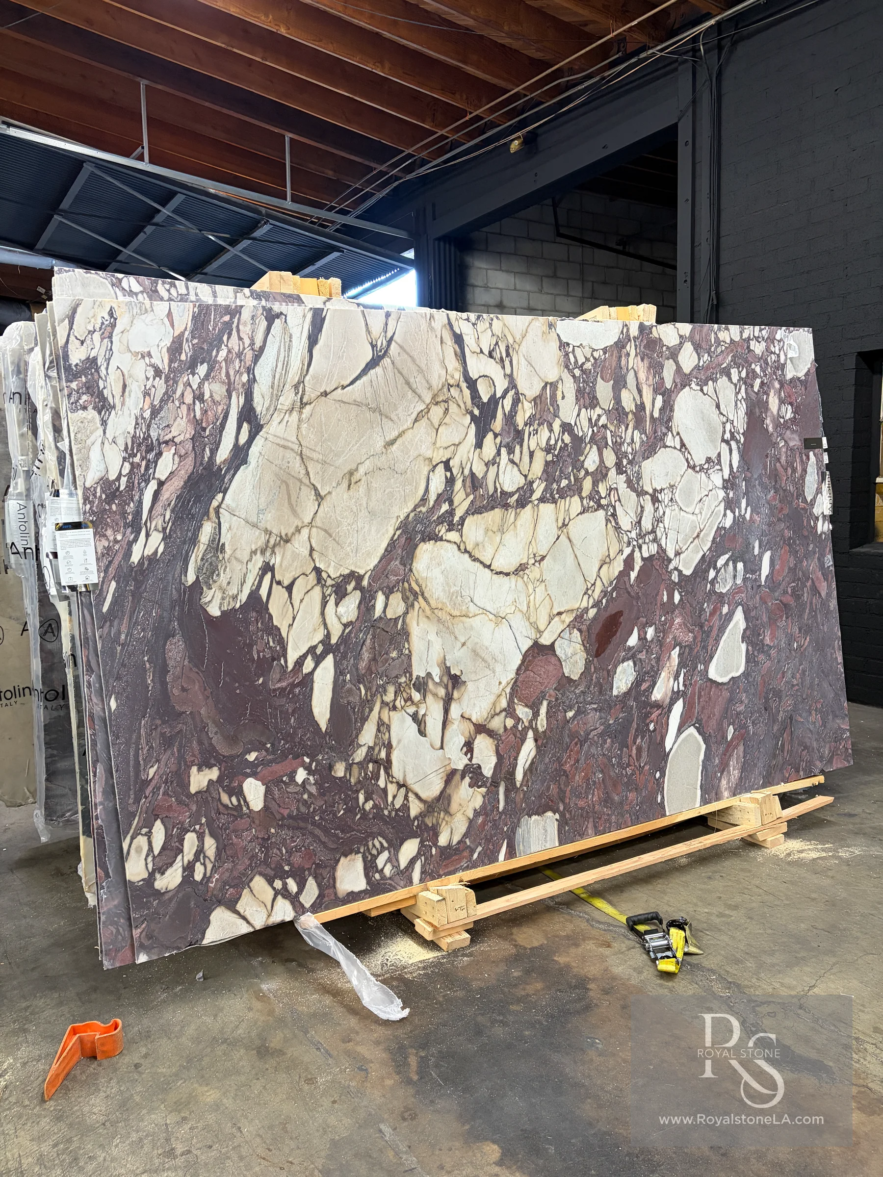 Antolini Calacatta Viola Top EE693 honed marble slab on the yard floor at Royal Stone in Los Angeles, showing cream, plum, violet, and charcoal brecciated movement