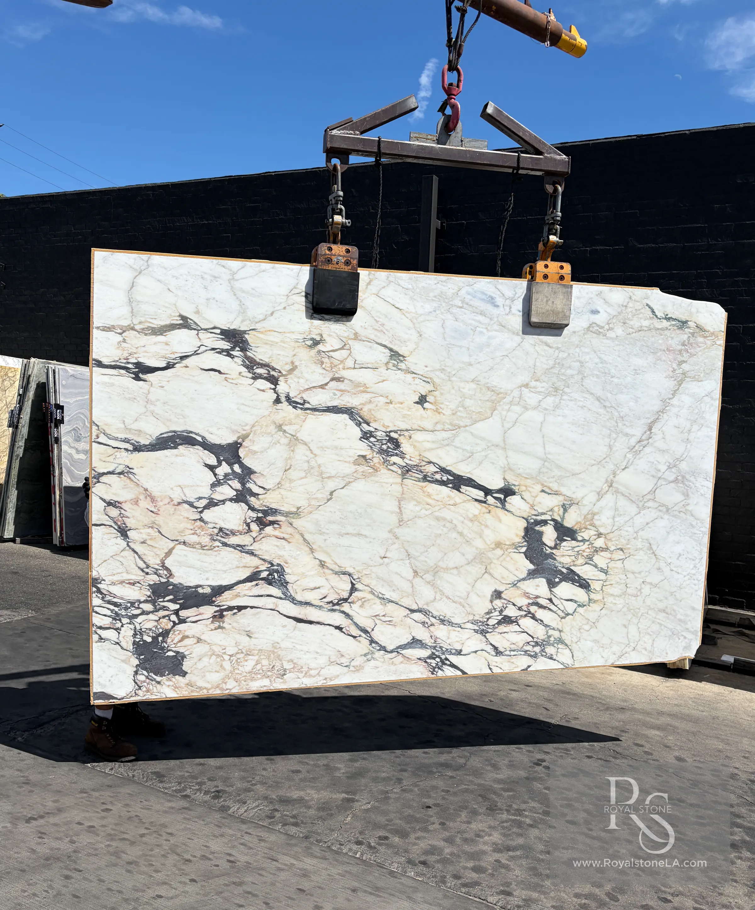 Additional yard view of the 2cm Antolini Calacatta Viola Top EG350 honed marble slab, 77 by 126 inches, suspended from the yard lift in daylight at Royal Stone Los Angeles