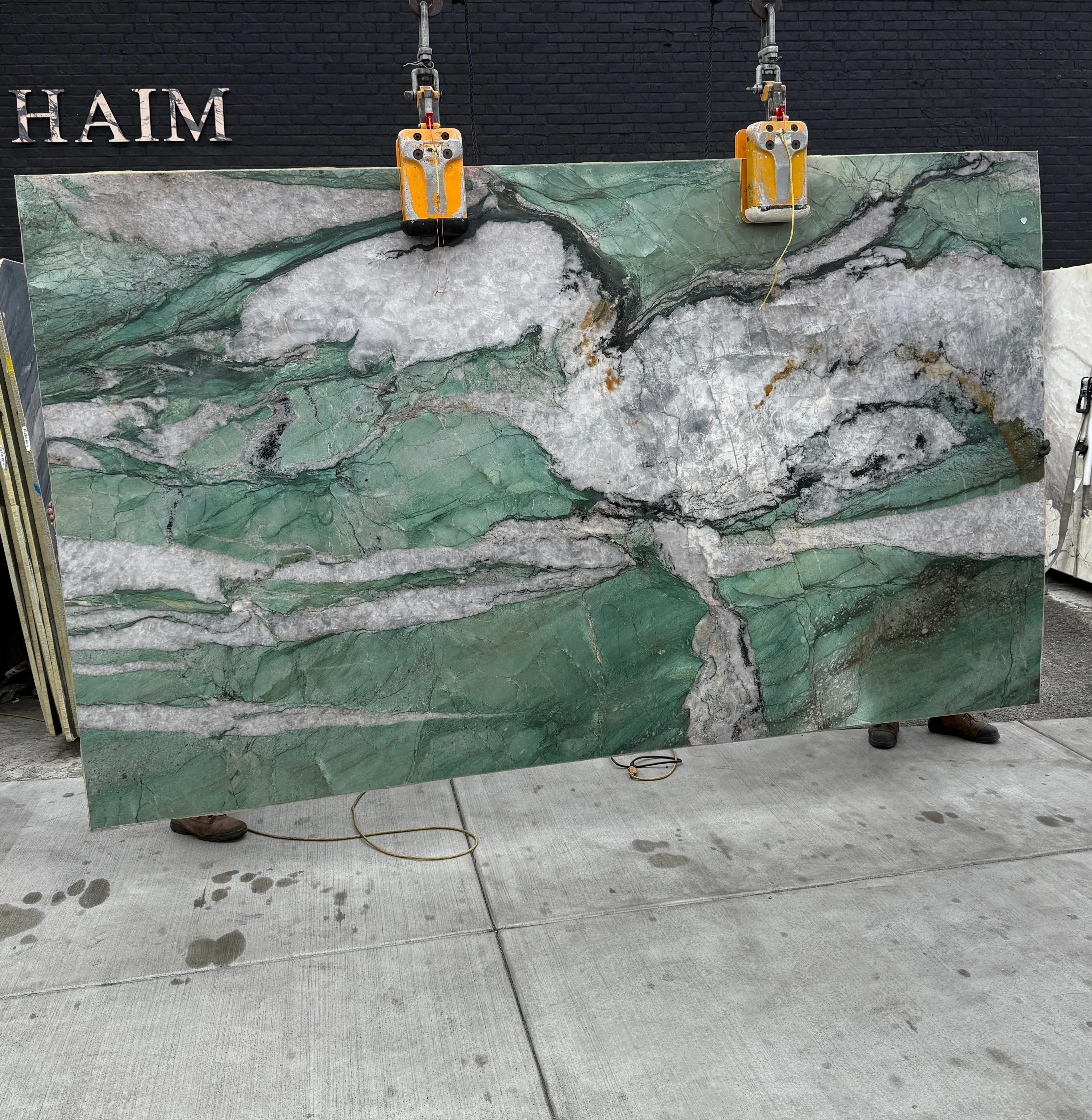 Antolini Cristallo Tiffany Jade Patagonia quartzite slab on the crane, jade-green field with crystalline white drifts, polished finish