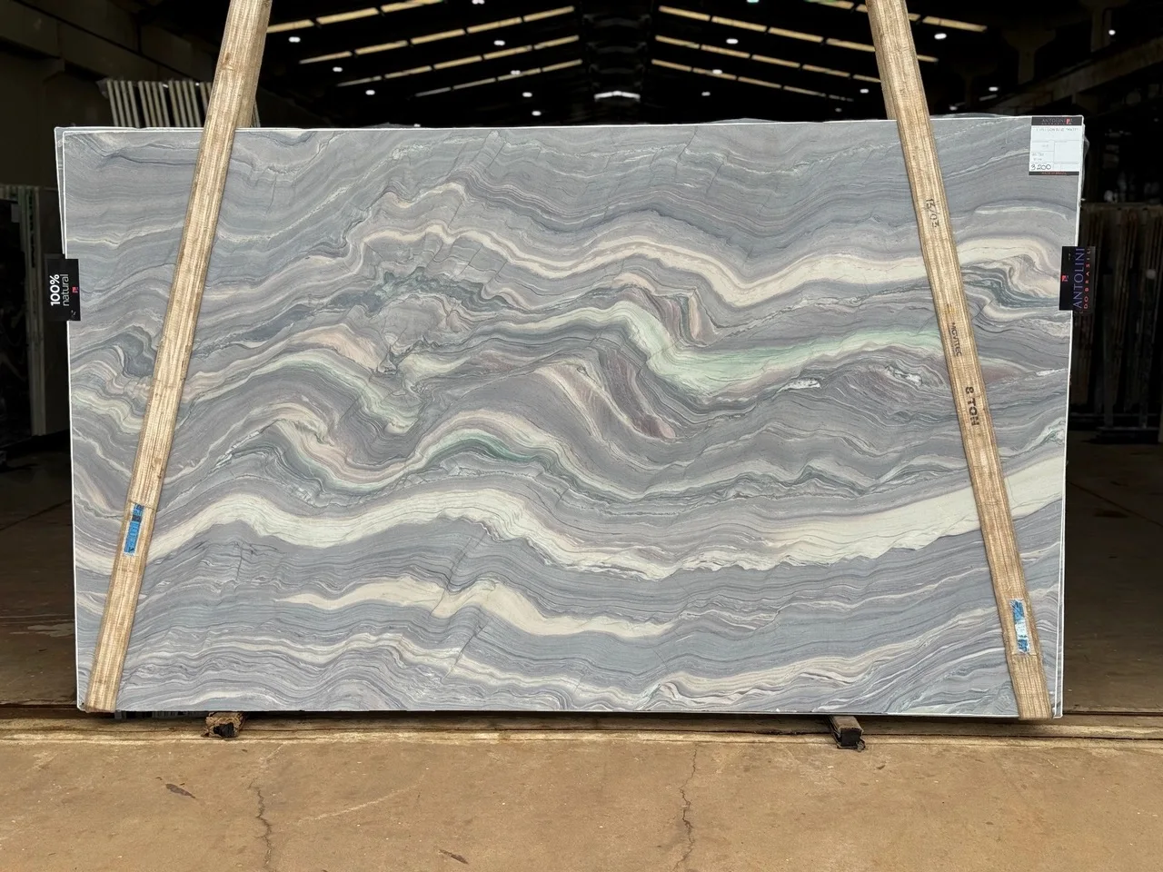 Antolini Explosion Blue Select quartzite slab with wavy blue, cream, and pink banded movement, polished finish