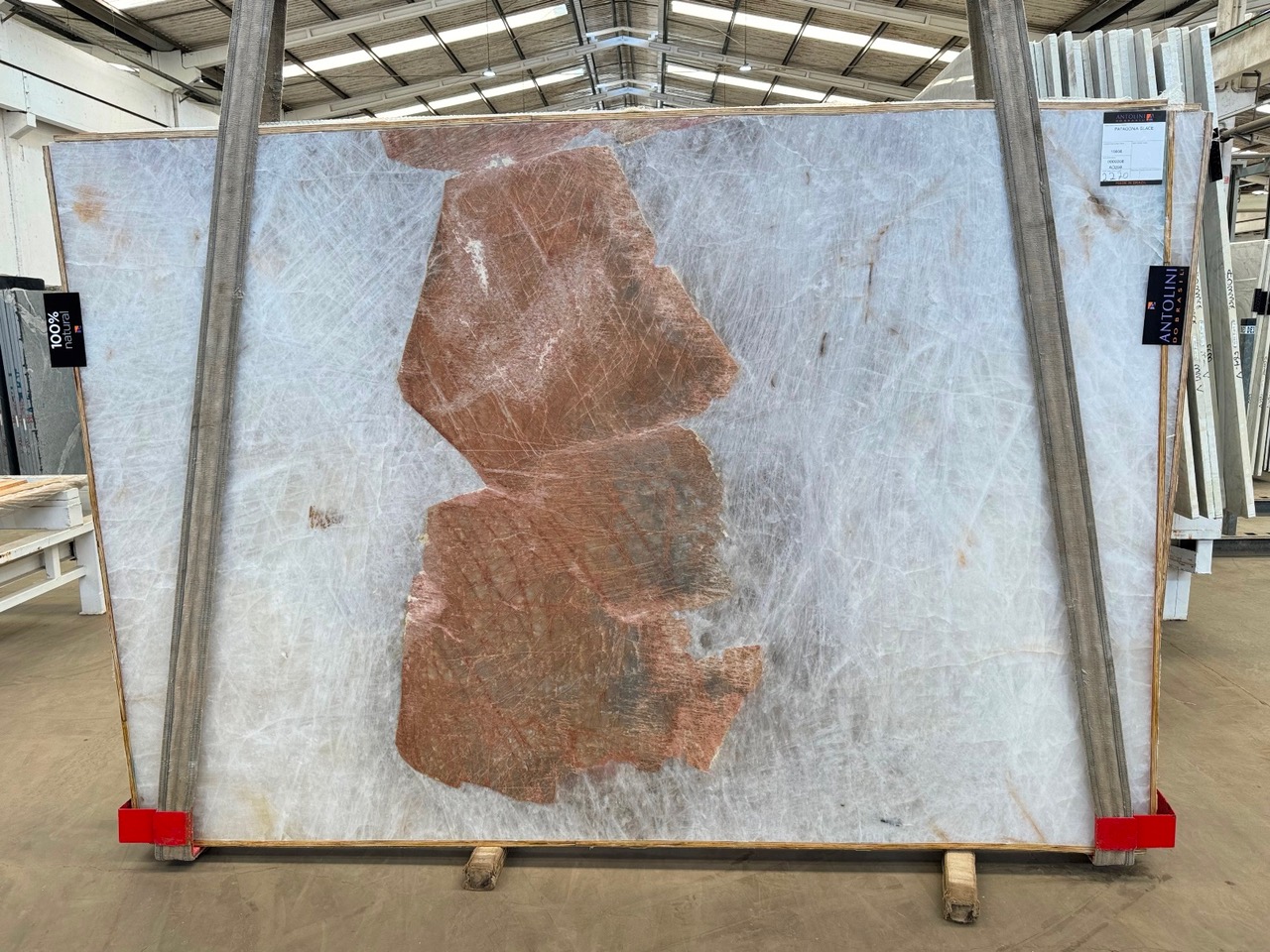 Antolini Patagonia Glace quartzite slab with cool translucent white field and a single warm copper mineral inclusion, polished finish