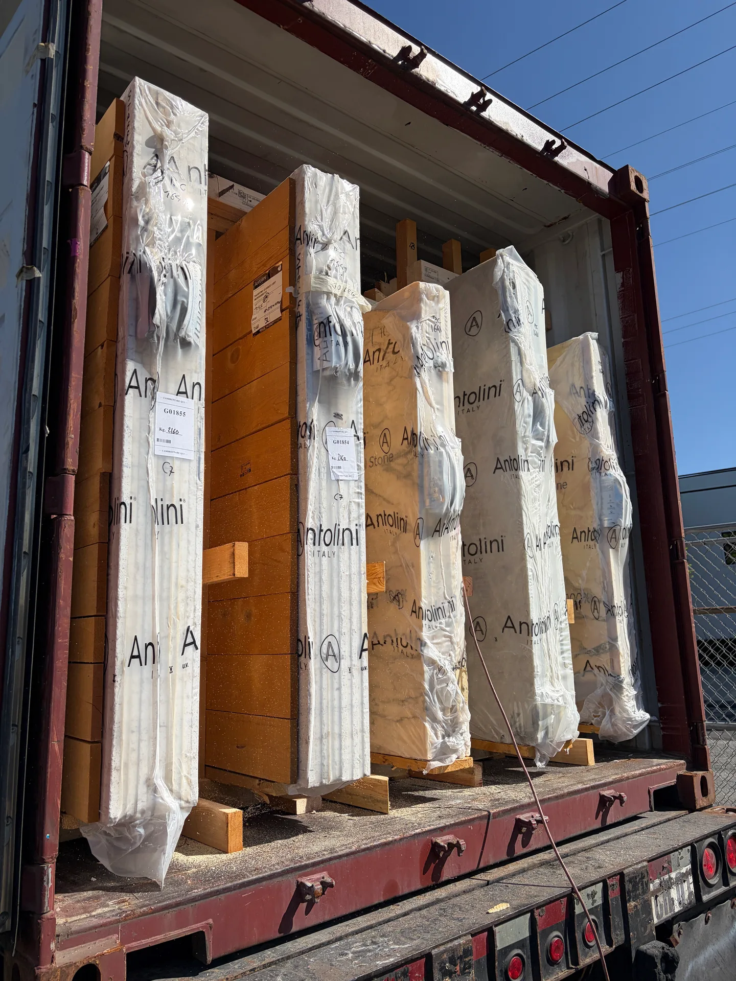 Antolini container opened at Royal Stone with wrapped natural stone slabs arriving from Italy in Los Angeles