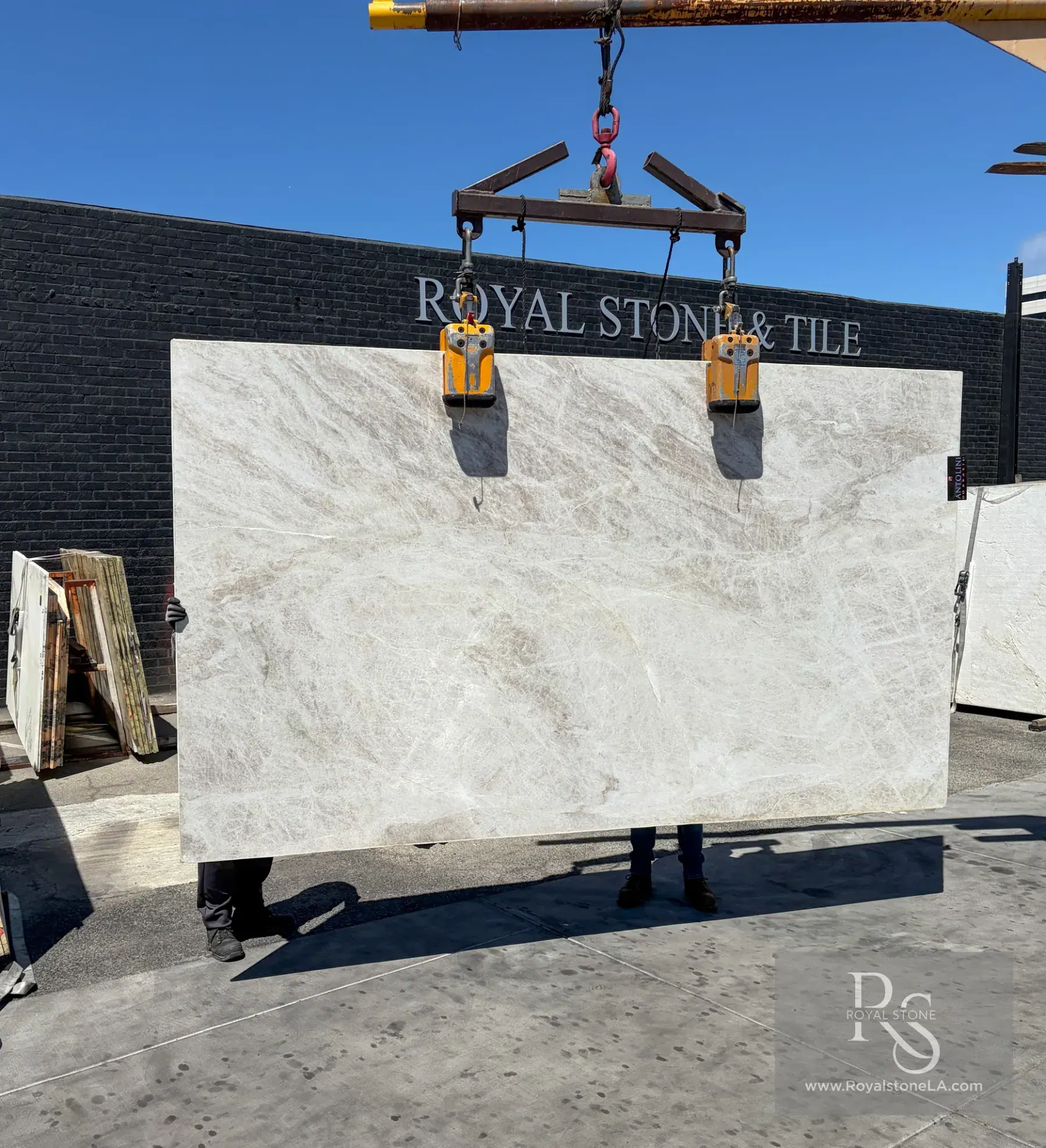 Antolini Taj Mahal Select quartzite slab in soft-leathered finish held against the Royal Stone & Tile yard wall in West Los Angeles — a Stone City yard representative delivery showing the deep Antolini inventory
