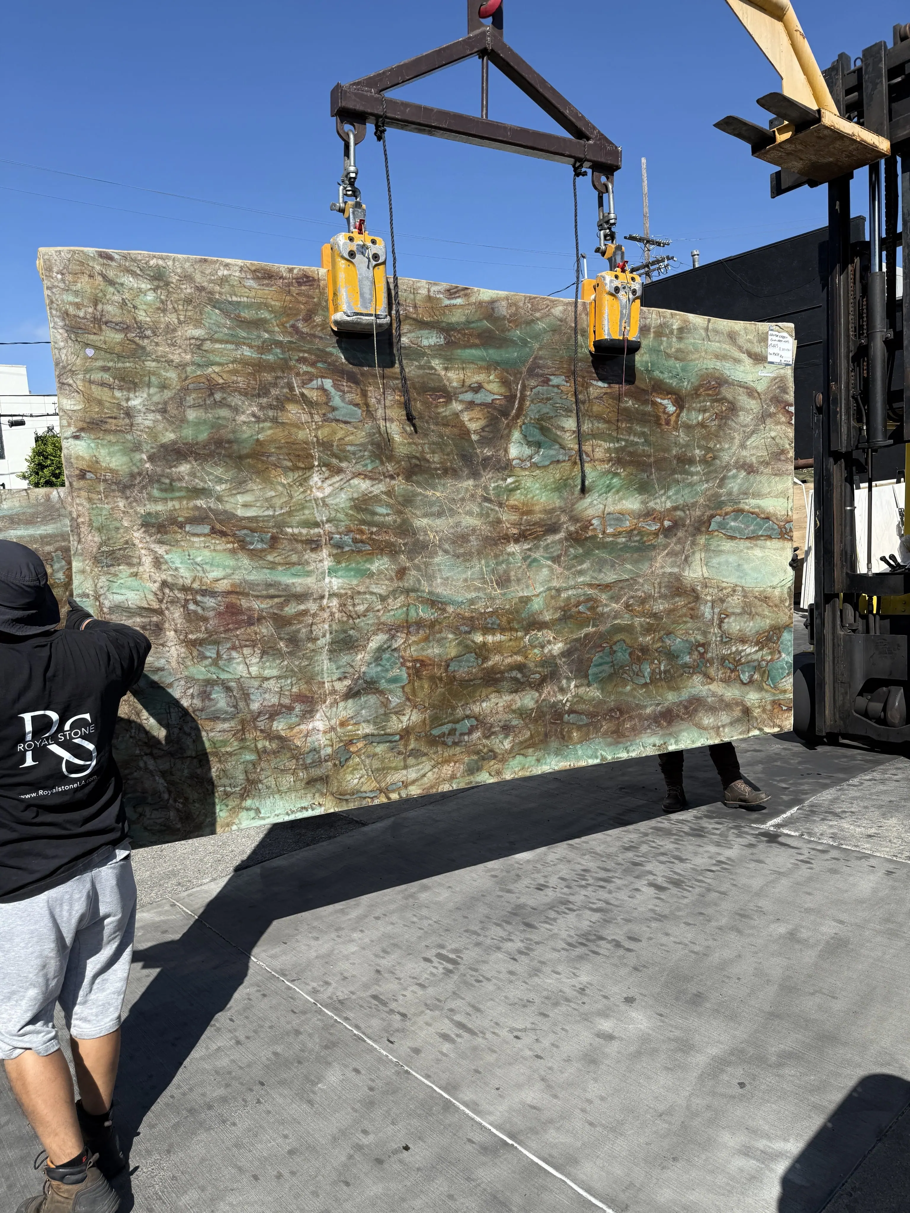 Antolini Van Gogh Louise Green quartzite slab lifted on the crane at the Royal Stone yard, mossy green field with copper veining and turquoise pockets
