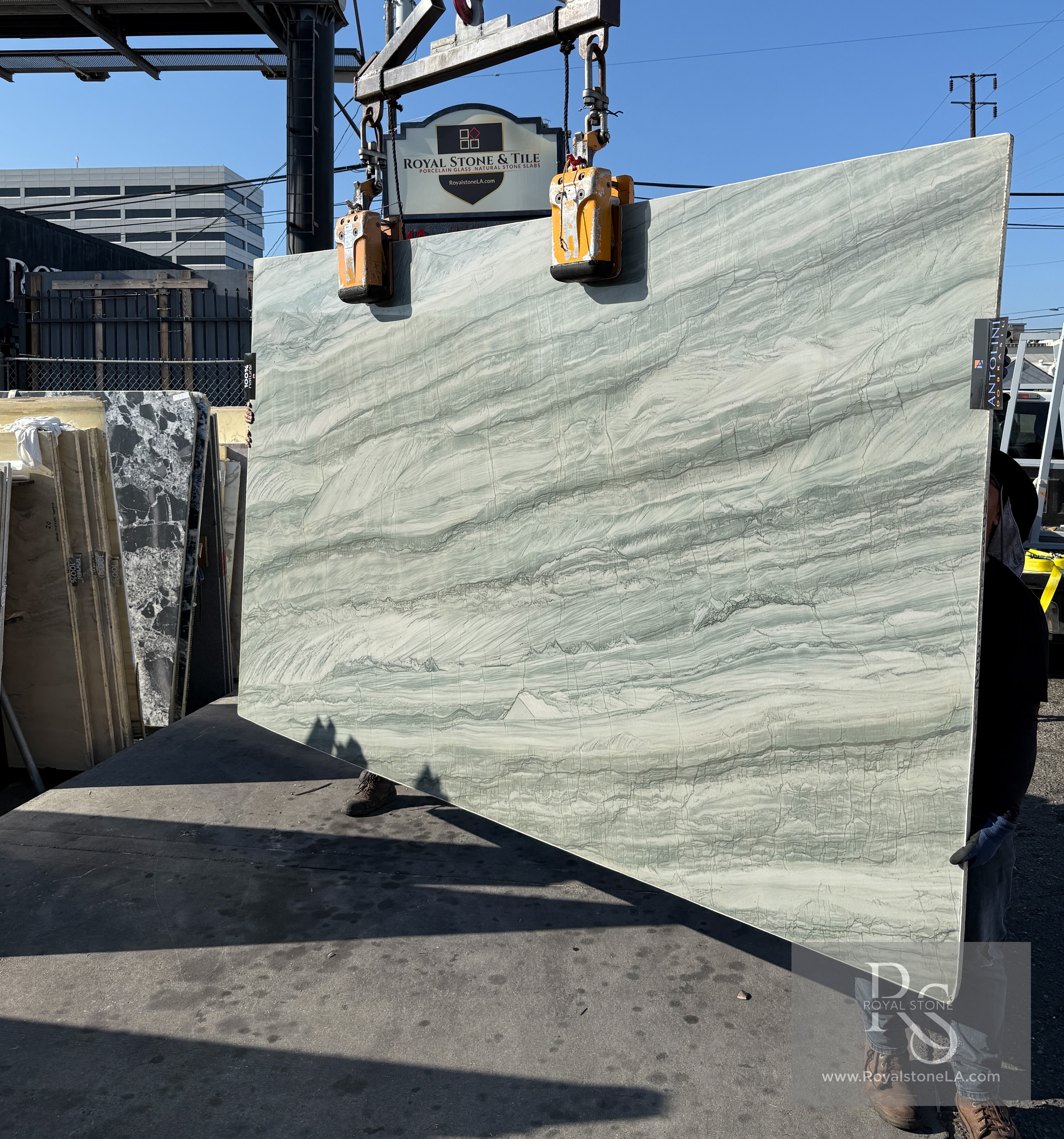Antolini Aqua Green Ocean quartzite slab on the crane at Royal Stone & Tile, soft aqua-green field with horizontal banding, polished finish, 76 by 126 inches