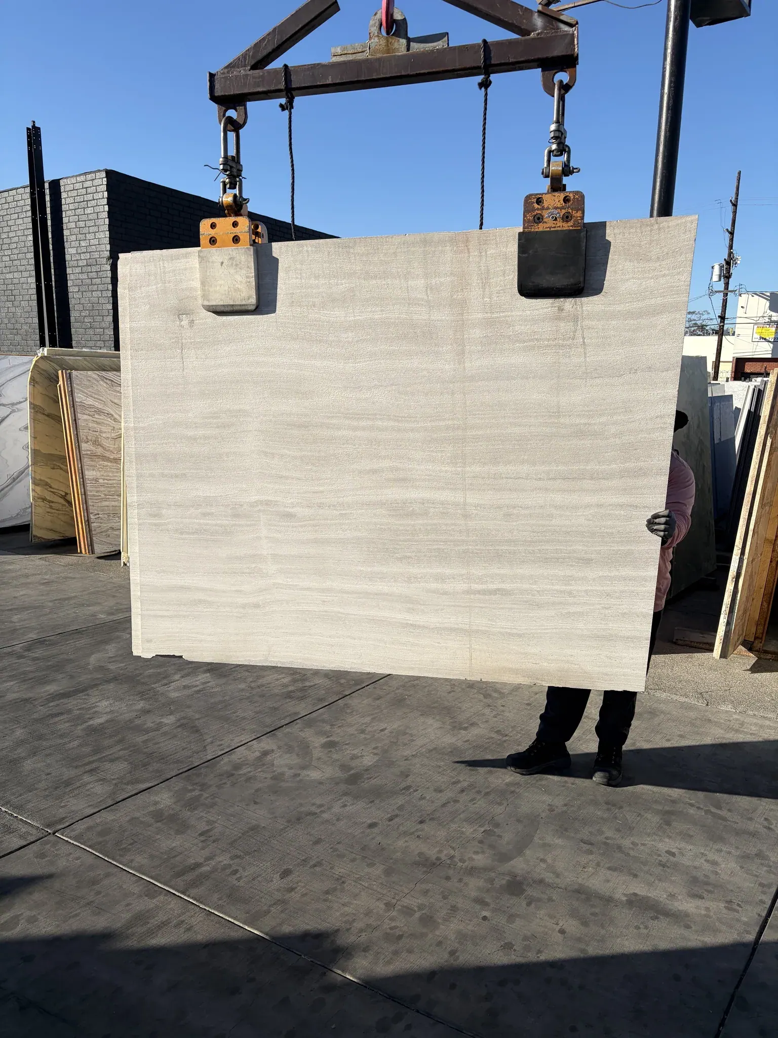 Athens Silver Haisa limestone sandblasted slab 66 by 72 inches at Royal Stone Los Angeles, soft silver-grey body with fine linear bedding