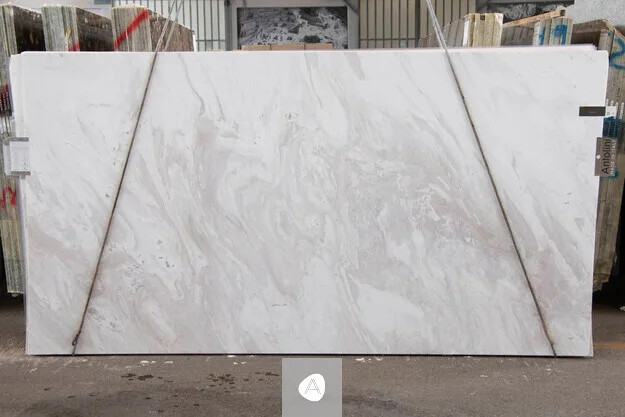 Calacatta Cremo marble slab with soft cream field and quiet taupe-grey swirl, polished