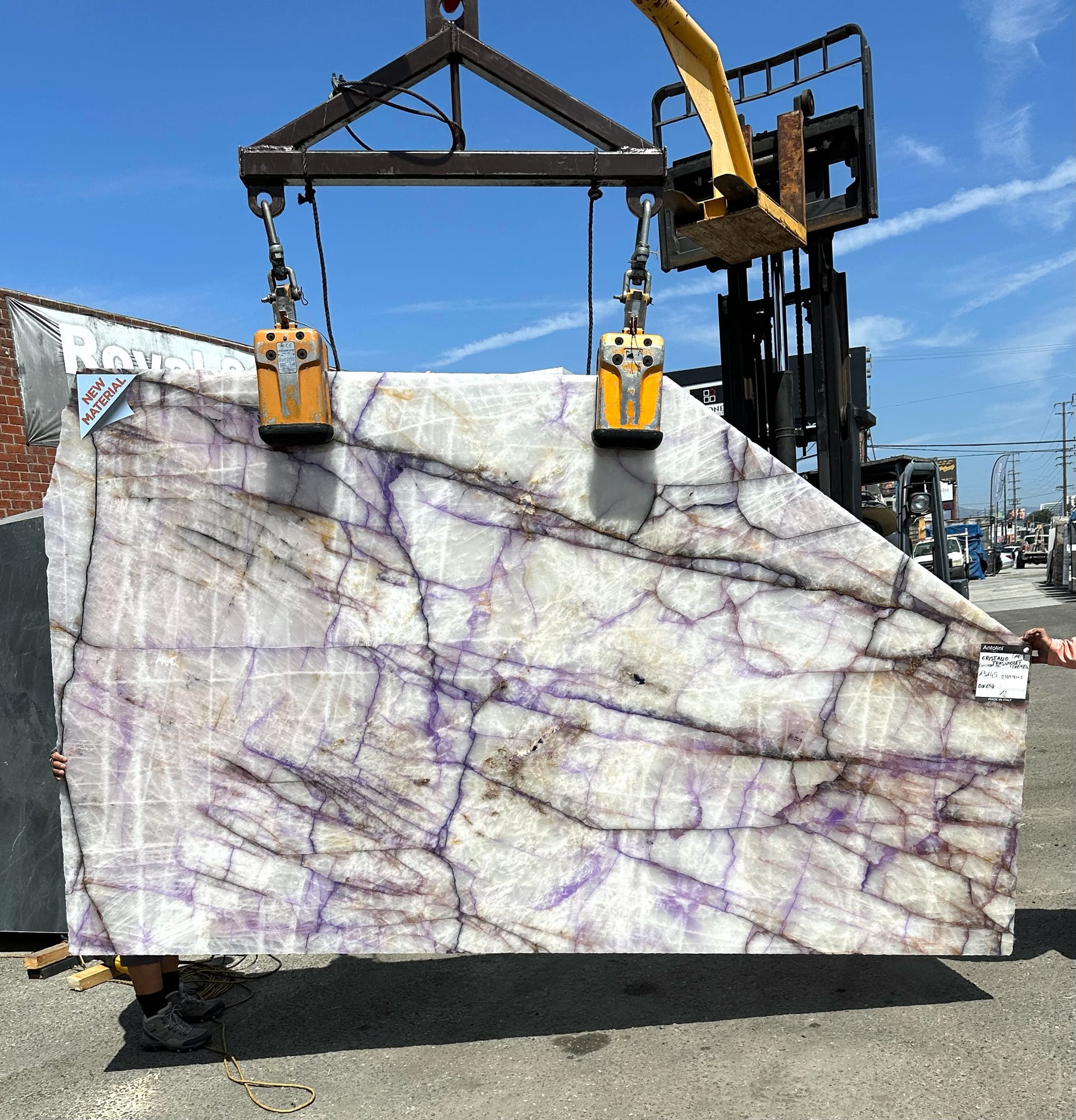 Antolini Cristallo Trasviolet polished translucent natural quartz slab with violet streaks and warm iron oxide threads on a clear white crystalline field at Royal Stone Los Angeles