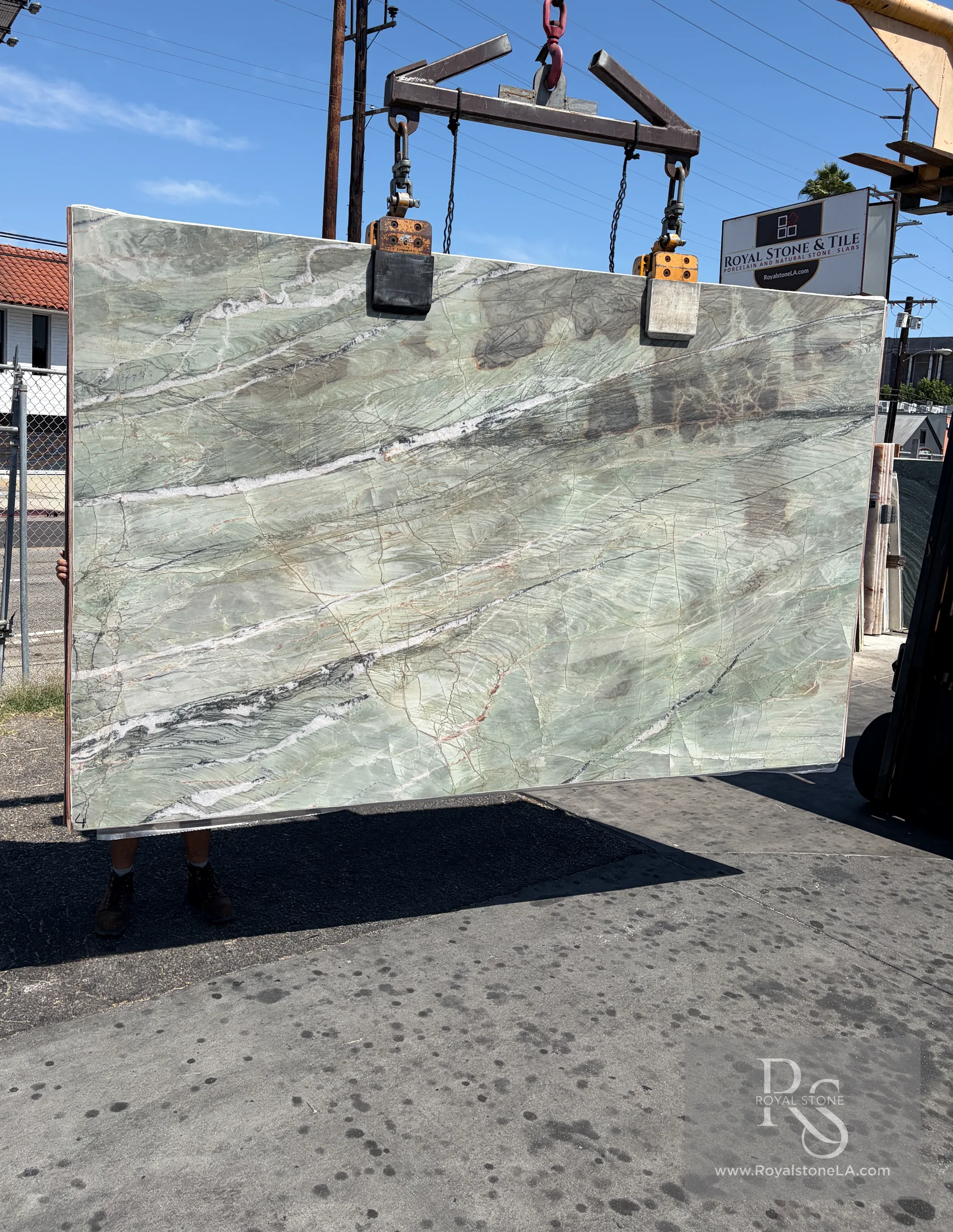 Emerald Green Patagonia Amazzoni honed quartzite slab BAS7783 suspended from the Royal Stone yard crane in daylight, 78 by 126 inches