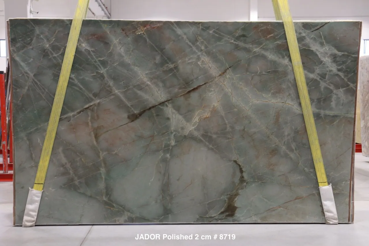 Jadore quartzite slab with translucent jade-green field crossed by rust and copper veining, polished