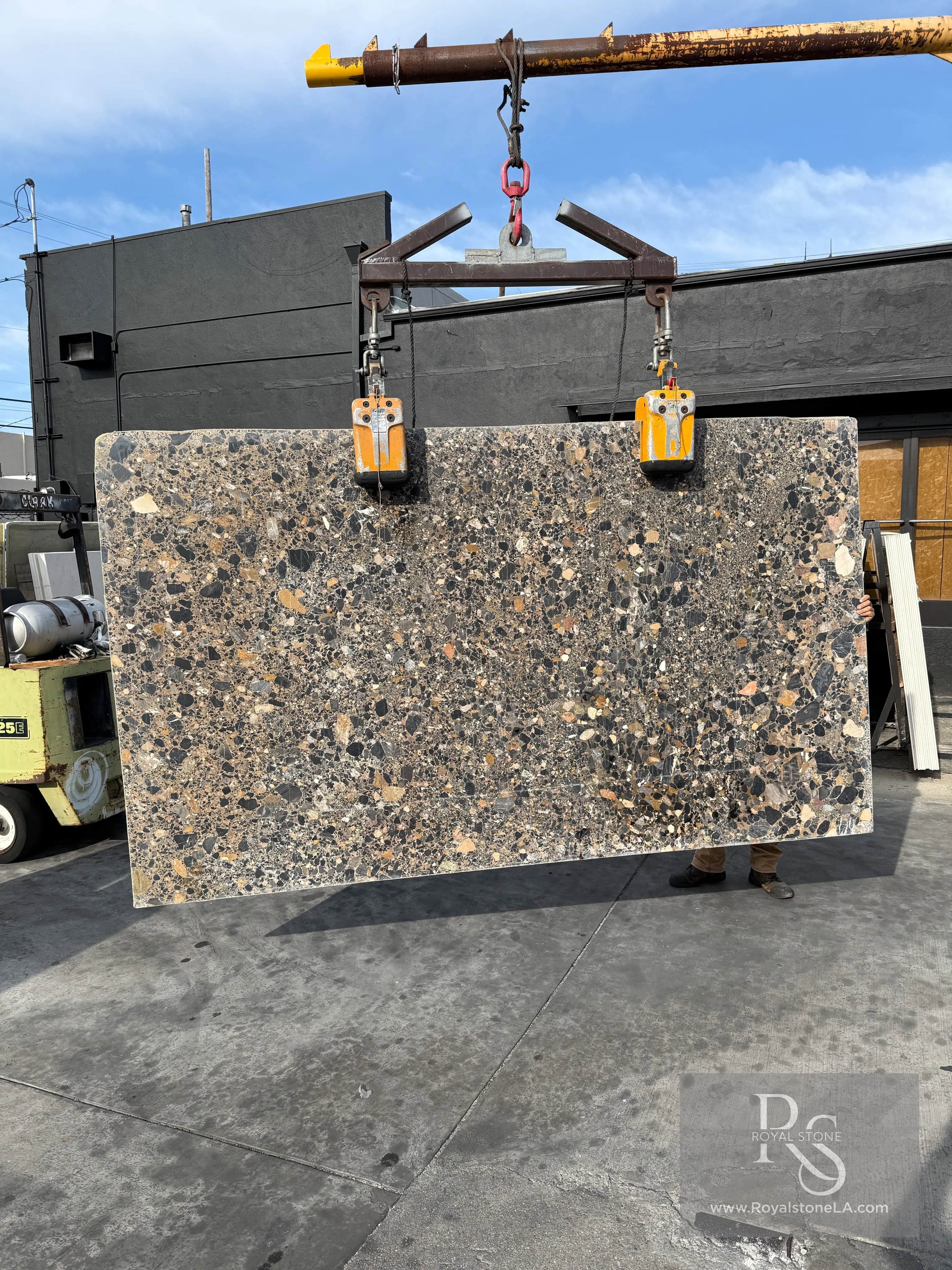 Paolo Ceppo Nero Warm leather-textured marble slab with charcoal ground and amber, ochre, and rust pebble inclusions at Royal Stone Los Angeles