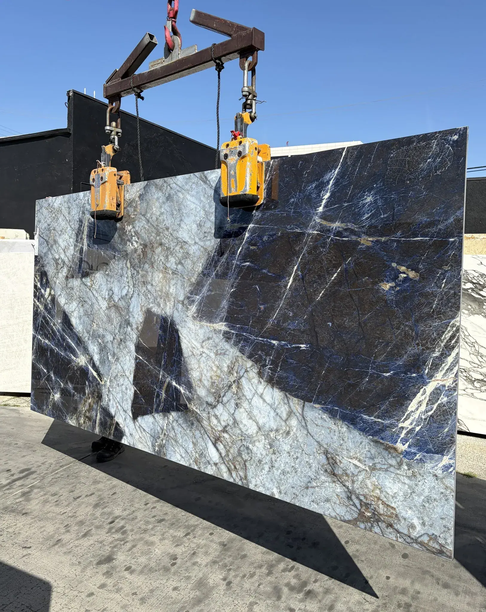 Second view of the same Patagonia Blue Sodalite Cristallo porcelain panel on the crane, showing the cobalt and indigo sodalite fields, the diagonal copper-rust vein, and the white crackle network running across the dark passages