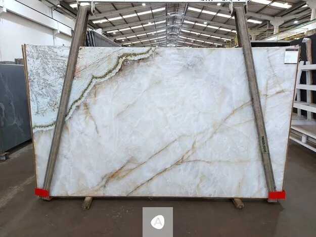 Antolini Patagonia Vitrum quartzite slab with translucent white field, warm gold veining, and a single jade seam, polished finish