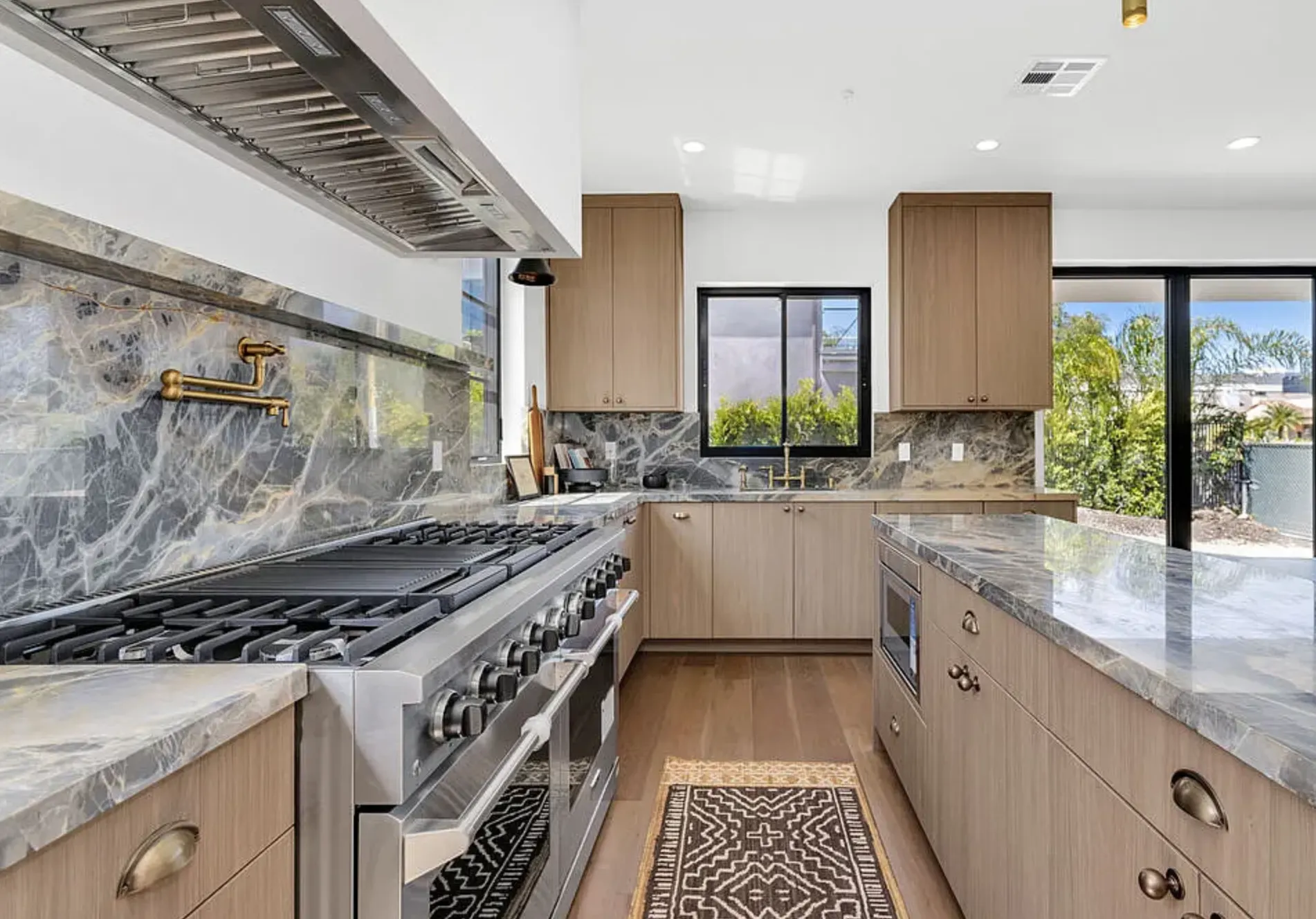 Portoro Gold Tempest polished marble range wall, backsplash, counters, and island in the 8671 Clifton Way kitchen