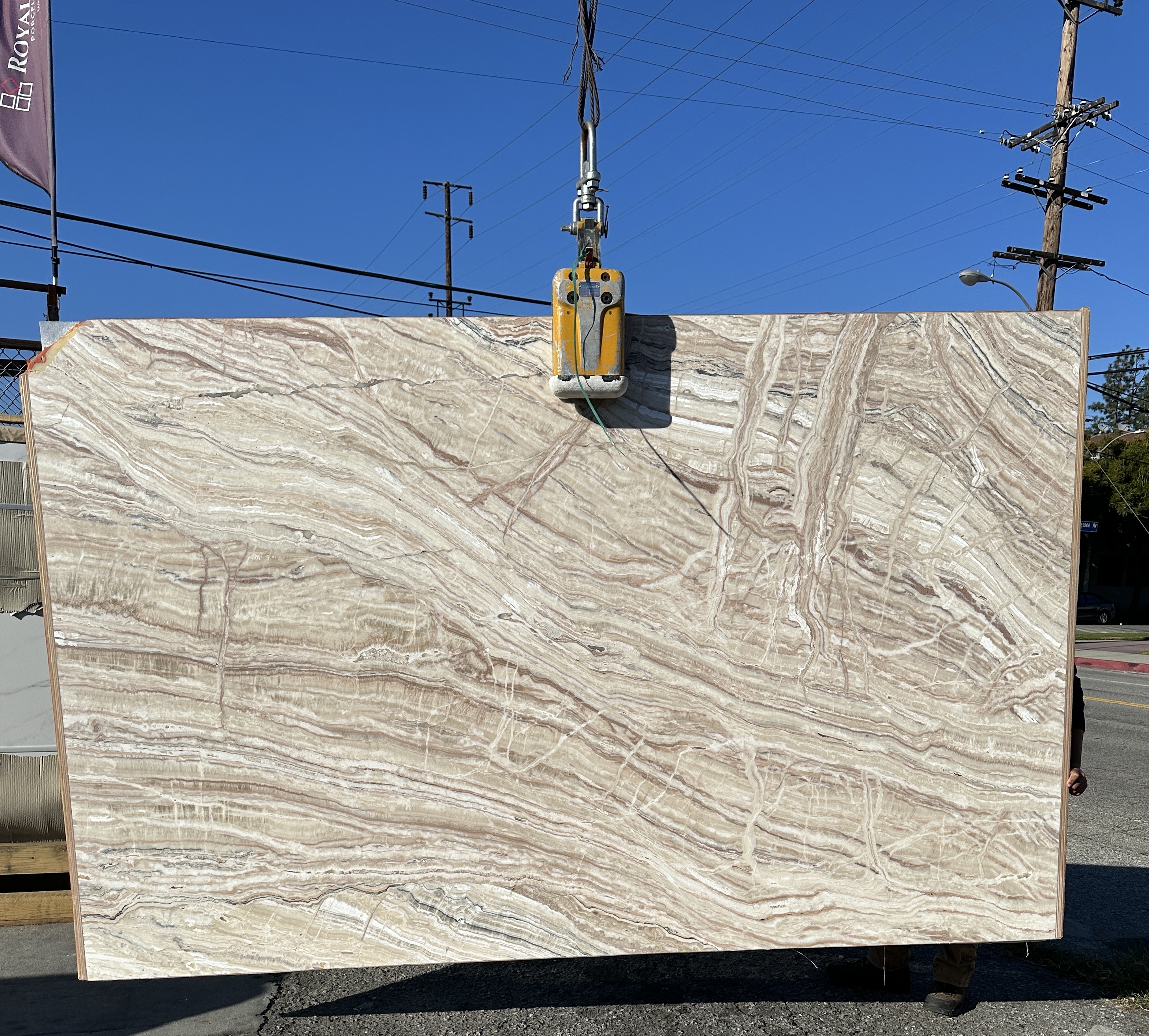 Synergy TraOnyx Rainbow Creme slab leathered at 71 by 113 inches at Royal Stone Los Angeles, cream and taupe linear banding with oxidized-rose drift