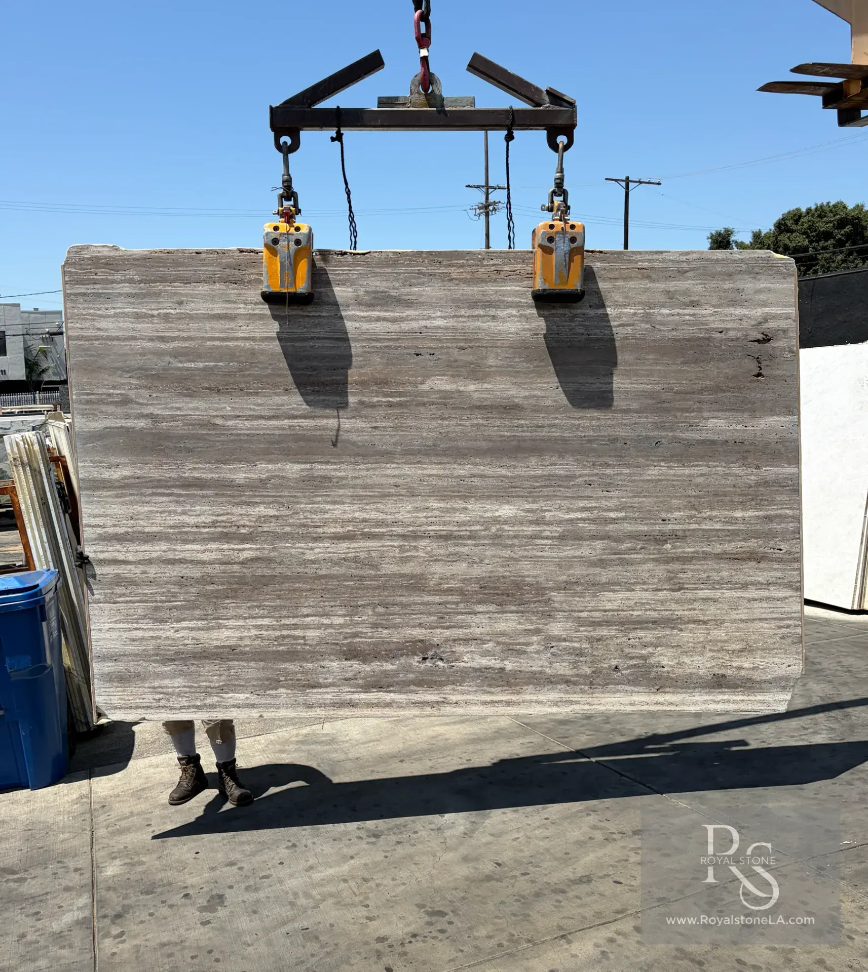Second full slab from the 32-slab Titanium Warm Shade Travertine lot, vein cut, filled and honed, shown on the crane at Royal Stone Los Angeles
