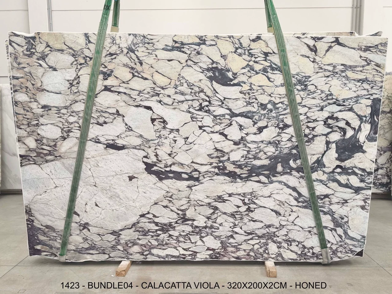 Calacatta Viola honed marble slab from bundle 04, with a warm white field and dense charcoal-violet breccia movement