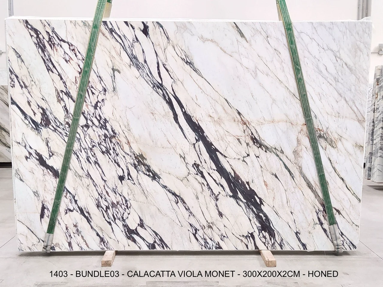 Calacatta Viola Monet honed marble slab from bundle 03, with an open white field crossed by sweeping charcoal, violet, and warm gold veining