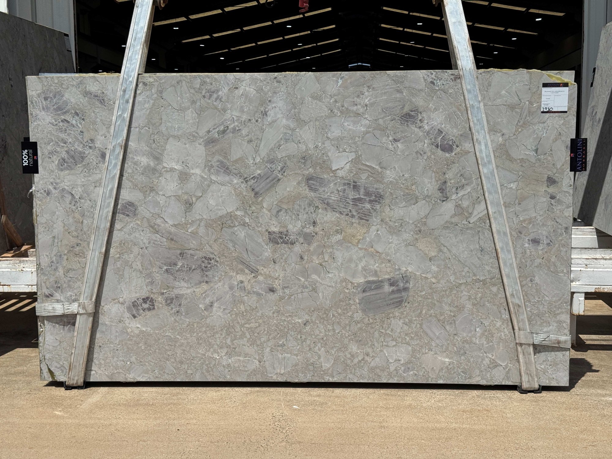 Antolini Arabesco quartzite slab from Brazilian Block EI289, a pale gray breccia with lavender clasts, leather finish, photographed at the stone yard