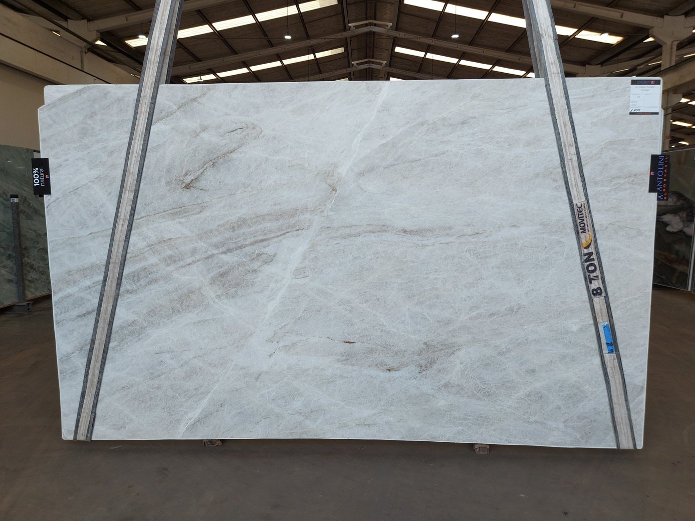 Antolini Taj Mahal Classic quartzite slab from Brazilian Block AO887, a soft white field with warm taupe veining, photographed at the stone yard