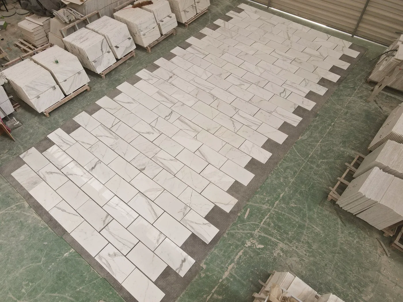 Italian Calacatta Gold 12 by 24-inch marble tile samples staged in final approval layout on the Royal Stone yard floor