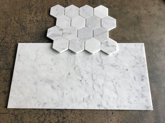 Honed Italian Carrara White marble 3-inch hexagon mosaic sample above a honed field tile, on concrete