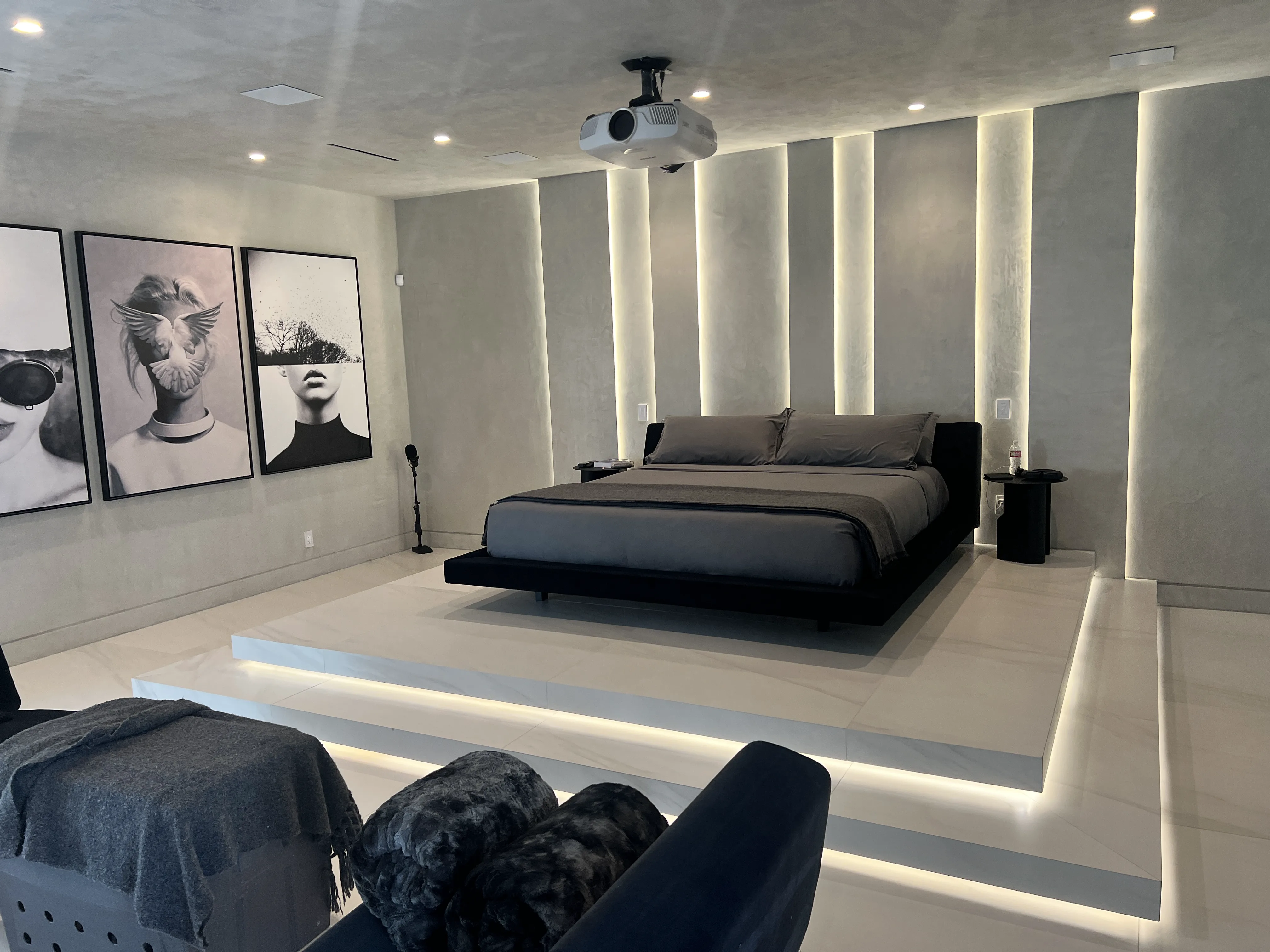 Eco Calacatta White honed 48 by 48 porcelain tile installed as flooring in a low-platform bedroom with upholstered bed and integrated LED step lighting
