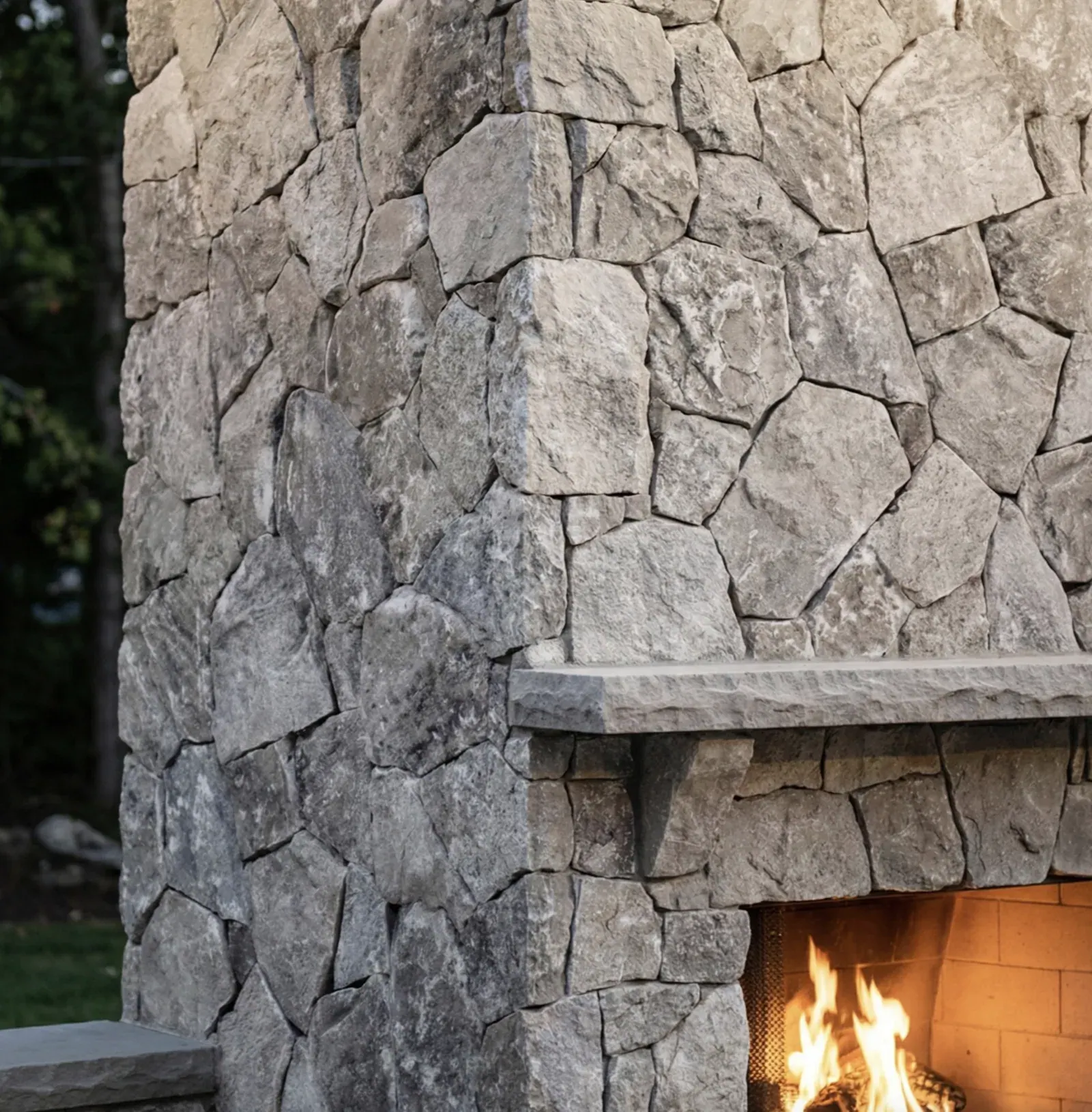Silver Travertine thin veneer installed around an outdoor fireplace