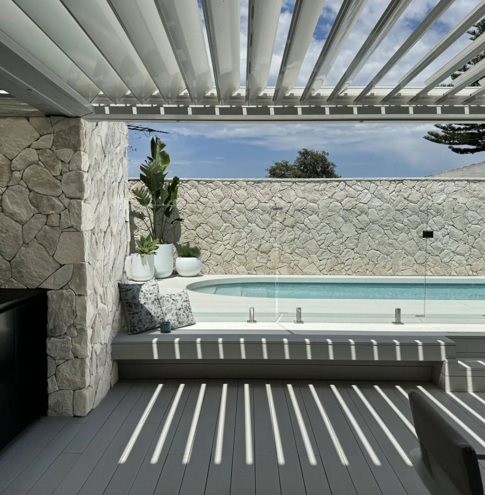Silver Travertine thin veneer installed around a poolside lounge