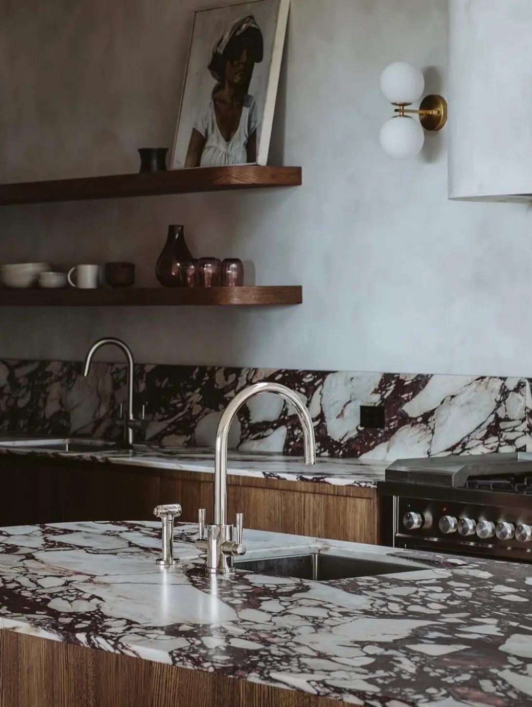 Kitchen with full-slab Calacatta Viola marble backsplash and bookmatched waterfall island in a working residence.