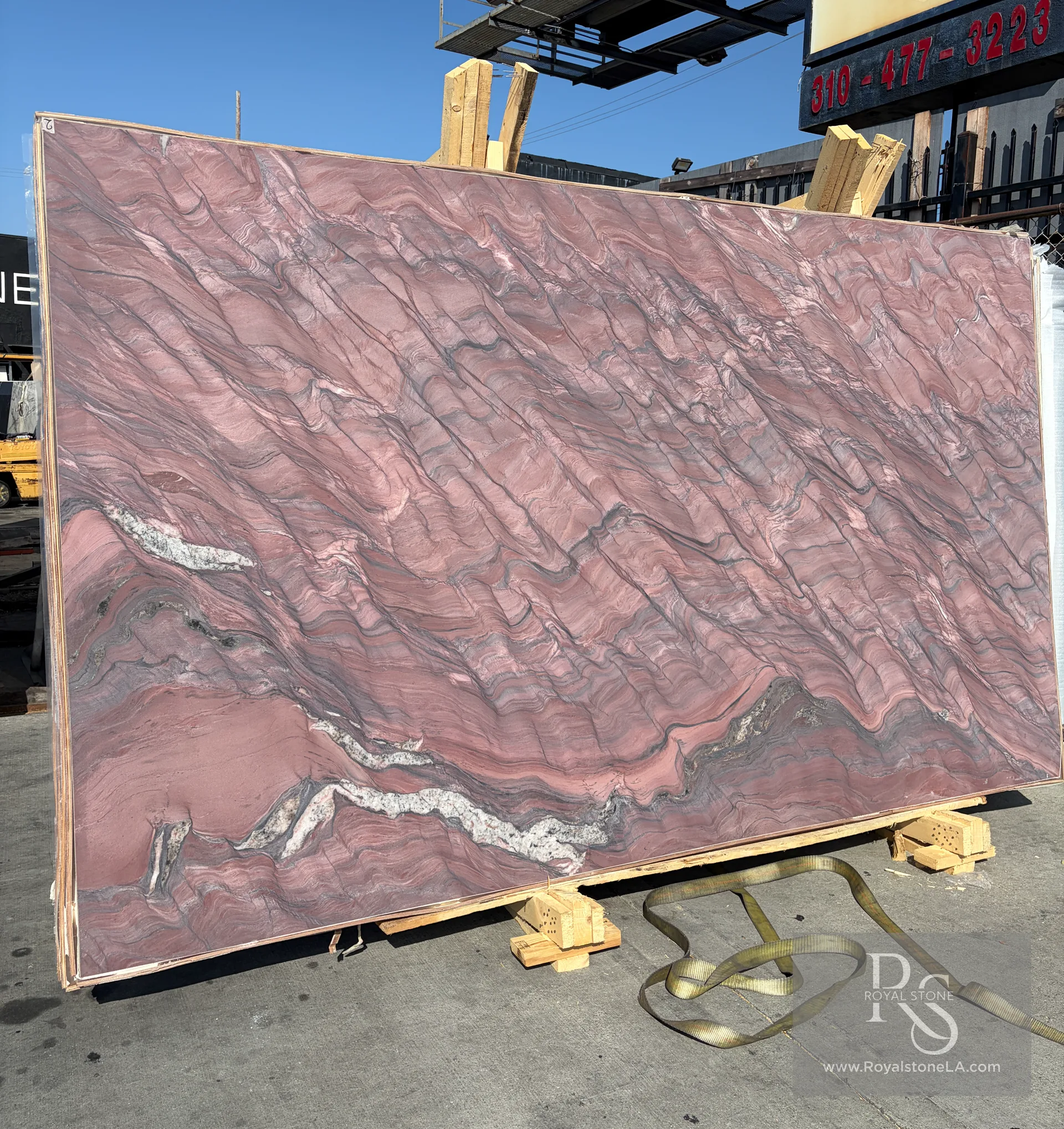 2cm Fusion Red Revolution honed quartzite slab, 78 by 130 inches, wide yard landscape view with the deep rose and mauve breccia running across the body and the white quartz seam crossing the lower third, leaned in the Royal Stone yard in Los Angeles