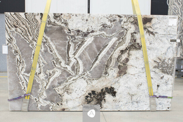 Antolini Patagonia Bianco quartzite slab with cream-white field and dramatic gray-brown veining, polished