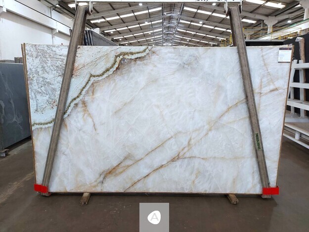 Antolini Patagonia Vitrum quartzite slab with translucent white field, warm gold veining, and a jade seam, polished