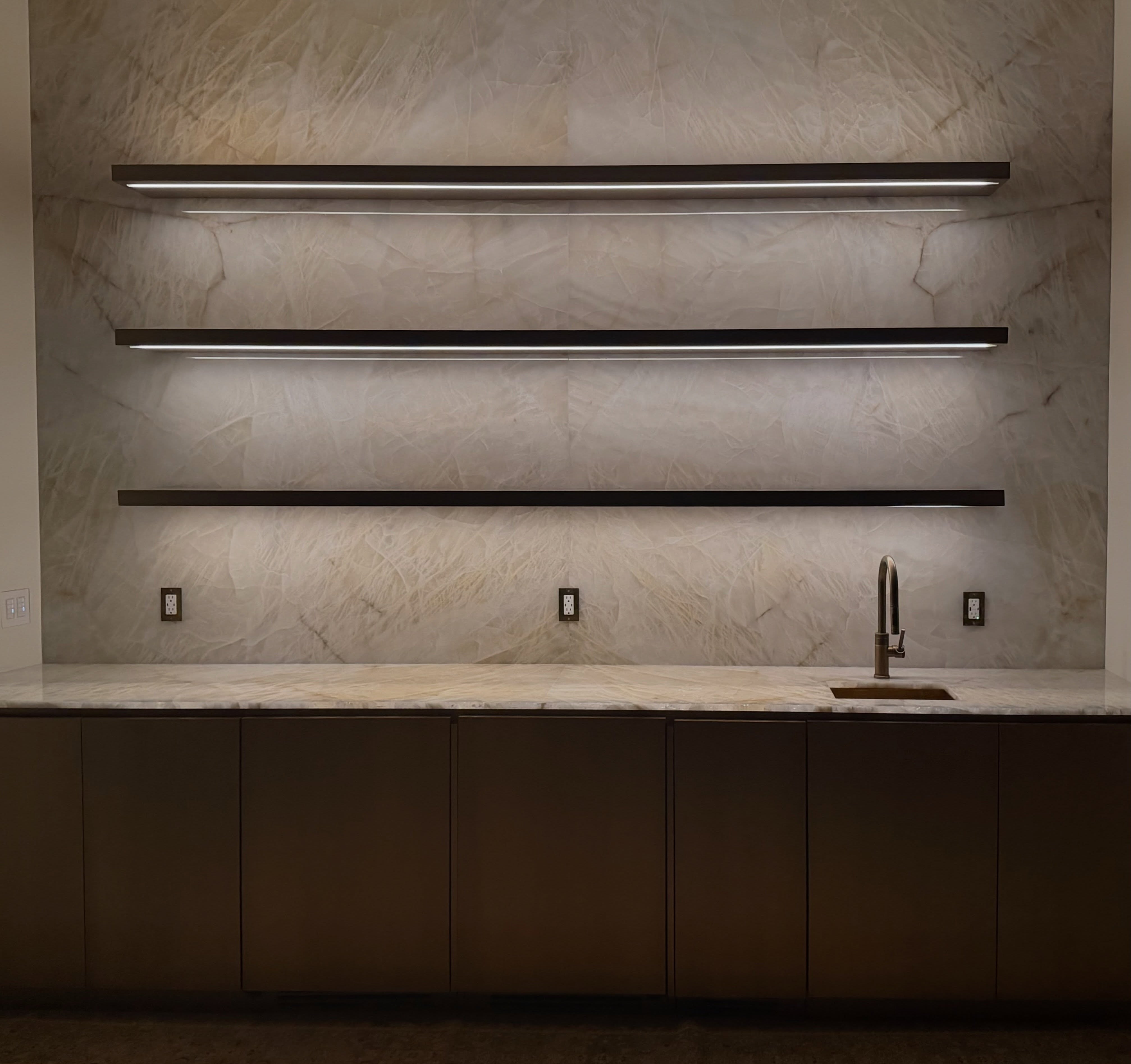 Luxury bar featuring Cristallo Rutile Diamond Quartzite on the wall and countertop, with three floating shelves.