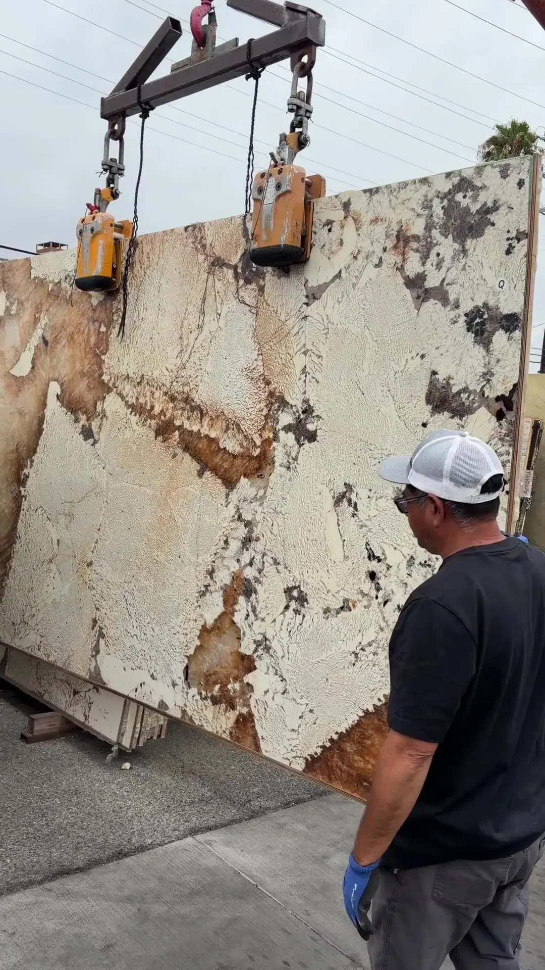 2cm Antolini Patagonia Original Unique AO683 polished slab, 75 by 121 inches — ivory and cream fragments scattered across a cool ground with amber, rust and burnt-orange veining, walked on the floor at Royal Stone Los Angeles